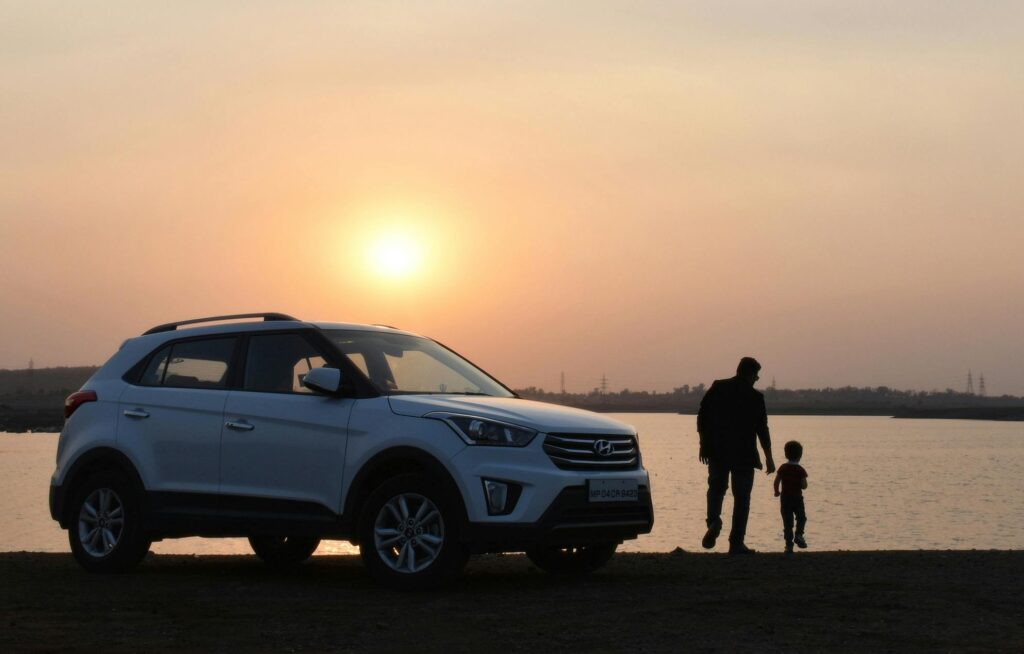 pexels-photo-1134857-1134857 A touching silhouette of a father and son beside a car at sunset by a lake in Bhopal, India.