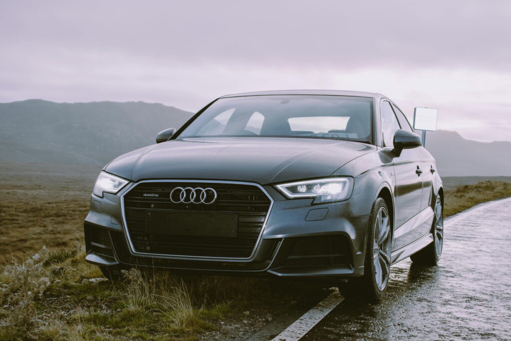 pexels-photo-1719647-1719647 Elegant grey Audi sedan parked roadside, showcasing luxury automotive design against a scenic backdrop.